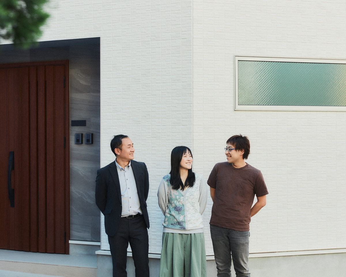 完成した住まいの前で話す三人
